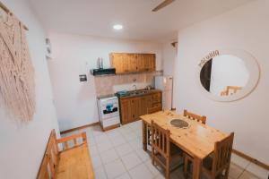 a kitchen with a wooden table and a dining room at Maluhia Home - Maio in Calheta Do Maio