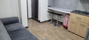 a living room with a couch and a counter and a stove at Apto con balcon in Pasto +2 photos
