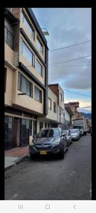a row of cars parked on a street next to buildings at Apto con balcon in Pasto