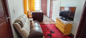 a living room with a couch and a television at Casita Vacacional in Copacabana