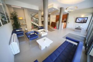 a hospital lobby with blue chairs and a table at Hotel Villa Igea Mhotelsgroup in Diano Marina
