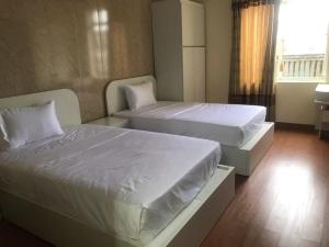 two beds in a small room with at Queenie Hotel 2 in Hai Phong