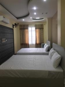 a bedroom with two beds and a window at Queenie Hotel 2 in Hai Phong +14 photos