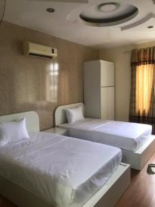 a bedroom with two beds and a ceiling at Queenie Hotel 2 in Hai Phong