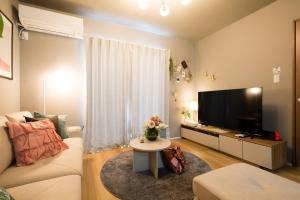 a living room with a couch and a tv at 巡り宿丸亀-最大9名 in Marugame