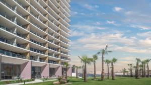 a rendering of a large apartment building with palm trees at Beachfront Luxury Studio in Puerto Peñasco