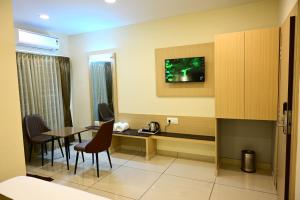 a room with a table and chairs and a kitchen at SR Grand in Tumkūr +31 photos