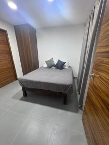 a bedroom with a bed and a wooden door at Modernos Departamentos Centricos in Ciudad Guzmán