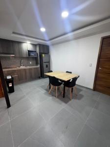 a kitchen with a wooden table and two chairs at Modernos Departamentos Centricos in Ciudad Guzmán +3 photos
