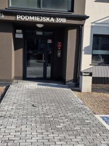 an entrance to a building with a brick walkway at Apartament Podmiejska Nova in Kalisz