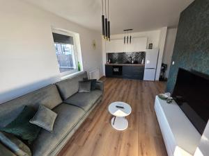 a living room with a couch and a table at Apartament Podmiejska Nova in Kalisz