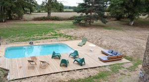 an overhead view of a swimming pool with chaises and chairs at Le Manoir du Châtelier in Bressuire