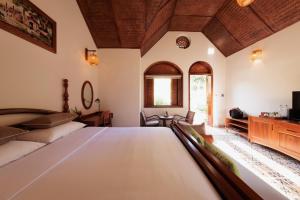 a hotel room with a bed and a television at The Bổi Heritage Tam Coc in Ninh Binh +55 photos