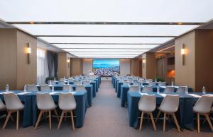 a conference room with blue tables and chairs at Orange Crystal Hotel Dali Erhai Park in Dali