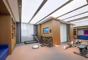 a gym with treadmills and exercise equipment in a room at Orange Crystal Hotel Dali Erhai Park in Dali