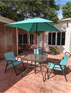 a table and chairs with an umbrella on a patio at Casa Tamarindo in San Carlos