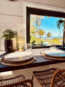 a table with two plates and glasses on top of it at Cape Byron Cabin in Coorabell Creek