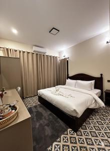 a hotel room with a large bed and a desk at The TARA PRABANG - Luangprabang in Luang Prabang +9 photos