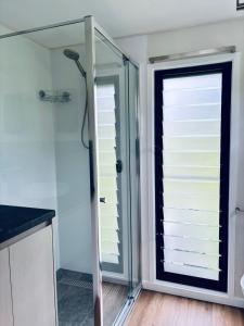 a shower with a glass door in a bathroom at Cape Byron Cabin in Coorabell Creek
