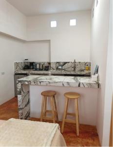 a kitchen with two stools and a counter top at Casa Tamarindo in San Carlos
