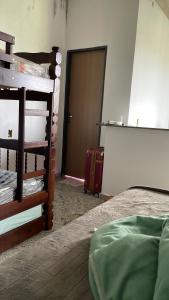 a bedroom with a bed and a door with a suitcase at Flat Recanto Brados in Sao Jorge