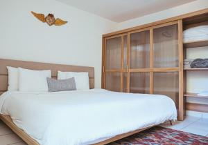 a bedroom with a large bed and a wooden cabinet at Viveros Centric and Comfortable Apt 2BR B Quintana Alamos in Laborcillas