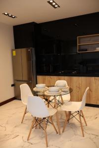 a kitchen with a table and chairs and a refrigerator at Ramon Luxury Suites in Gualaceo