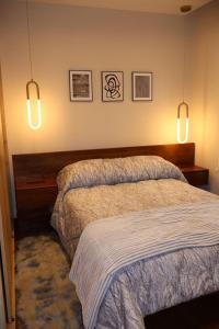 a bedroom with two beds and two lights on the wall at Ramon Luxury Suites in Gualaceo