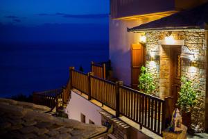 una casa con balcón por la noche en Lions Nine, en Mouresi