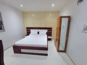 ein Schlafzimmer mit einem Bett und einem Spiegel in der Unterkunft Hôtel Semto in Edéa + 7 Fotos
