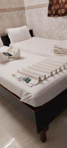 two twin beds with white sheets and shoes on them at Hotel Kamal in Mumbai
