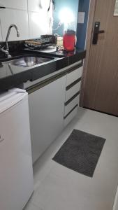a kitchen with a sink and a counter top at Studio moderno e bem localizado in João Monlevade +19 photos