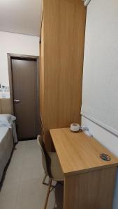 a small room with a desk and a bed at Studio moderno e bem localizado in João Monlevade