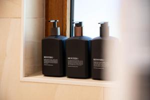 three bottles ofodorizers sitting on a shelf in a bathroom at 25 Walkers Lane in Bright +31 photos