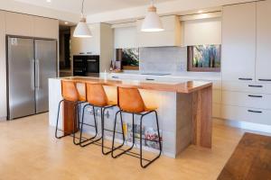 a kitchen with a counter with orange bar stools at 25 Walkers Lane in Bright
