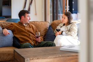 a man and a woman sitting on a couch with wine glasses at 25 Walkers Lane in Bright