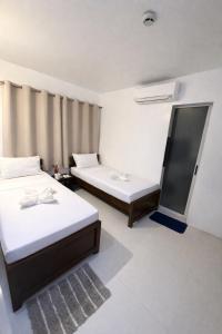 a room with two beds in a room at Iwayan Beach Resort in Panglao Island