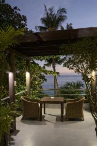 a patio with a table and chairs and the ocean at Iwayan Beach Resort in Panglao Island
