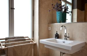 een badkamer met een witte wastafel en een spiegel bij Linnen in Berlijn