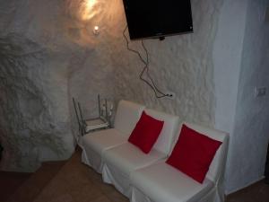 アルカラ・デル・フカルにあるCasa Rural El Jacuzziのリビングルーム(白いソファ、赤い枕2つ付)
