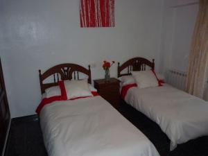 アルカラ・デル・フカルにあるCasa Rural El Jacuzziの白と赤のシーツが備わる客室のベッド2台