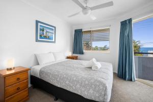 a bedroom with a bed and a window with the ocean at Kings Way Apartments in Caloundra +57 photos