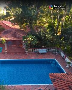 a swimming pool in a yard next to a house at Pousada das Cores Cocais in Barão de Cocais