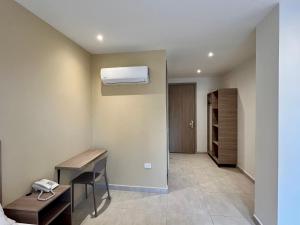a room with a desk and a air conditioner on the wall at BQ84 Urban Hotel in Barranquilla