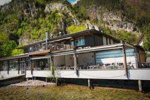 a building with a mountain in the background at Beachhouse Isleten in Bauen
