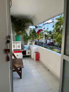 ein Balkon mit einer Bank und Topfpflanzen in der Unterkunft Mi Refugio Dive House in Cozumel