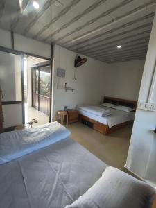 a bedroom with two beds and a large window at Sleek Haven in Meppādi