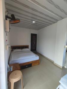 a bedroom with a bed and a stool in it at Sleek Haven in Meppādi
