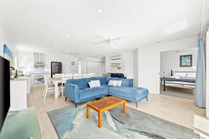 a living room with a blue couch and a table at Unit 8 Boardwalk Apartments in Narooma