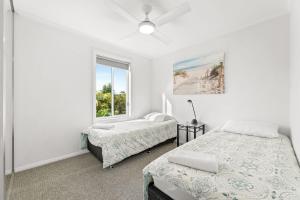 a bedroom with two beds and a window at Unit 8 Boardwalk Apartments in Narooma